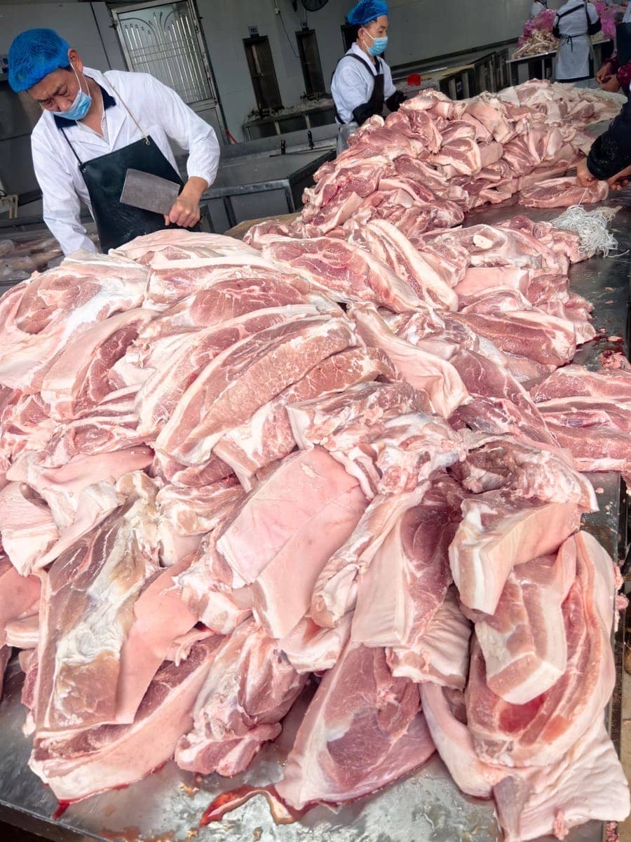 分割车间员工处理鲜猪肉